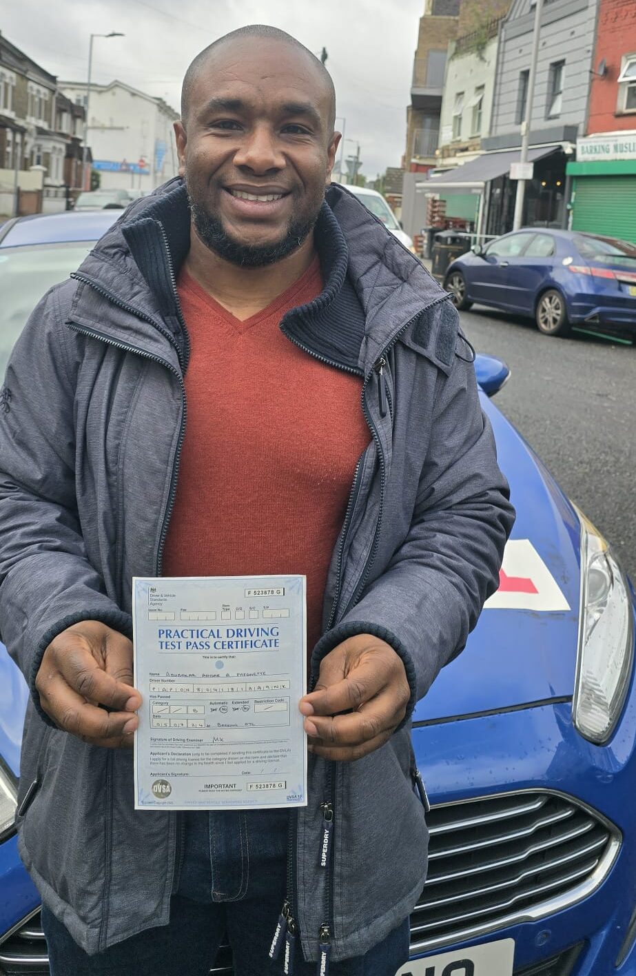 Proud student with certificate after affordable automatic car lessons near Leyton.