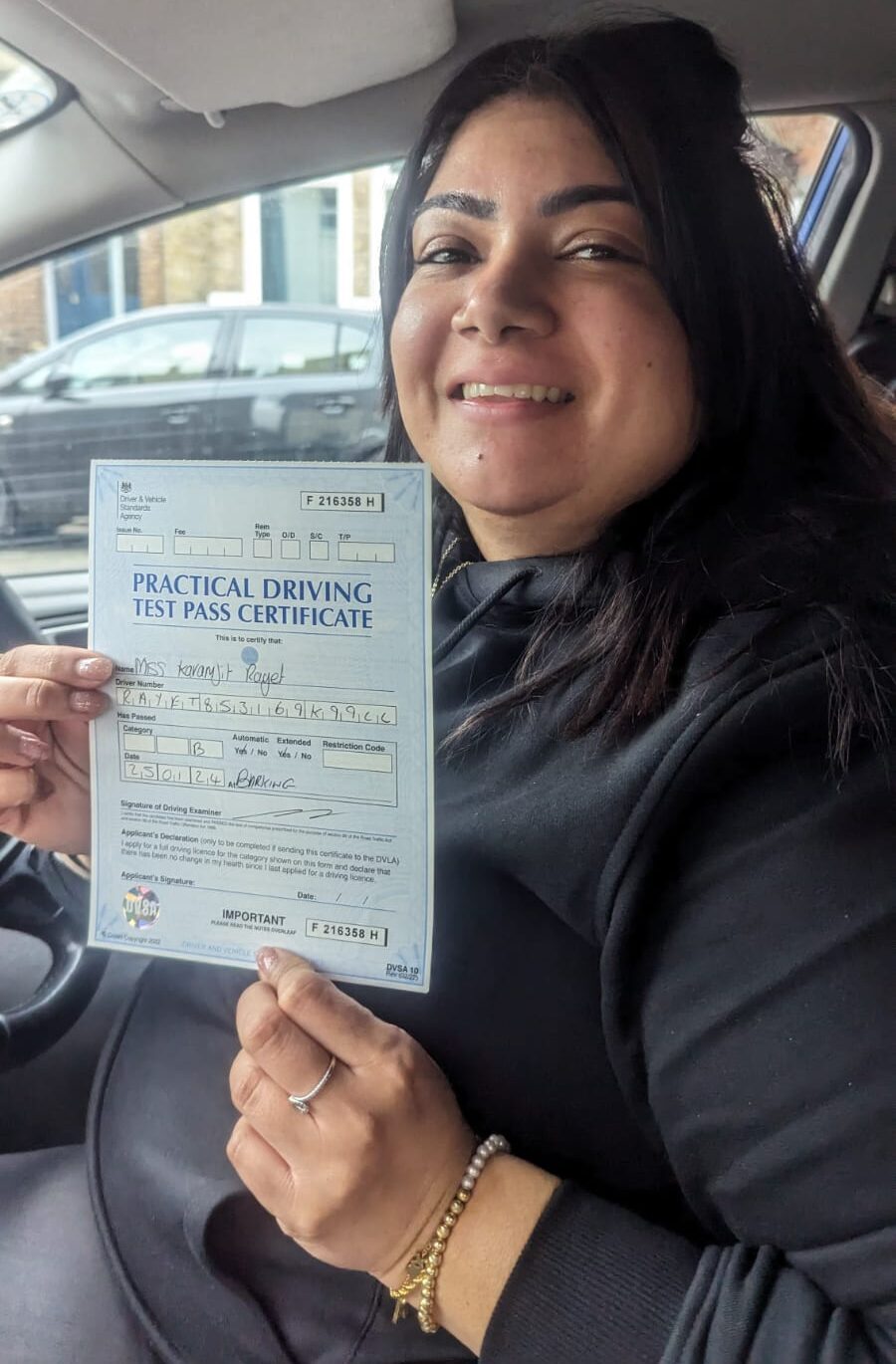 Smiling learner proudly holding their certificate after taking automatic driving lessons near Plaistow