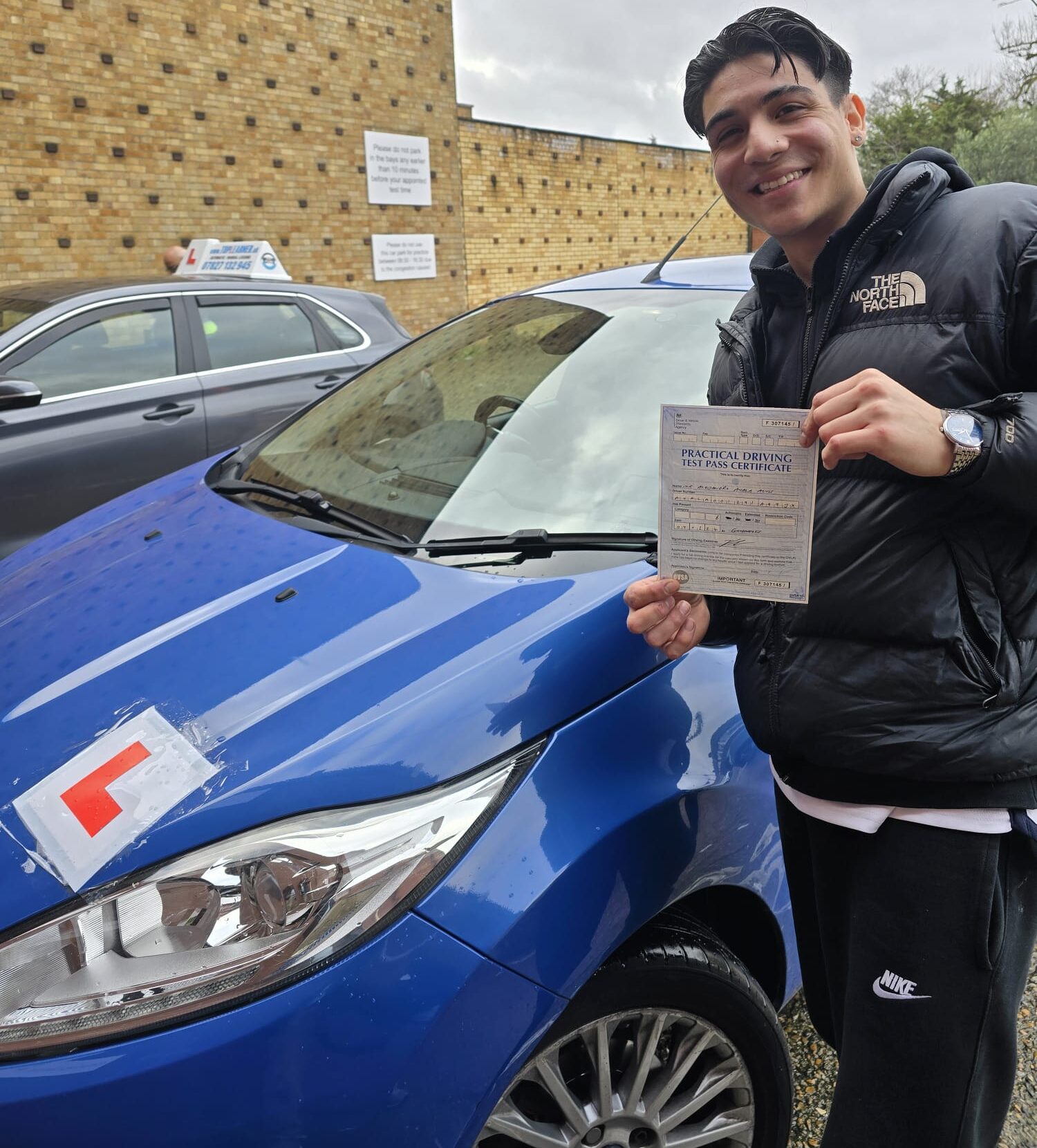 Newly licensed driver thanking their instructor after automatic car lessons in East London.